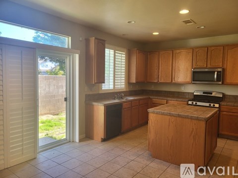A kitchen with wooden cabinets and a brown island.
