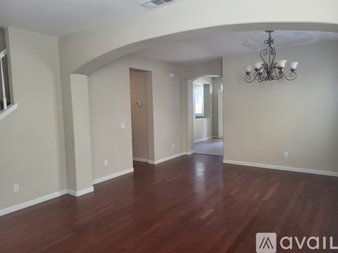 A room with wooden floors and a chandelier.