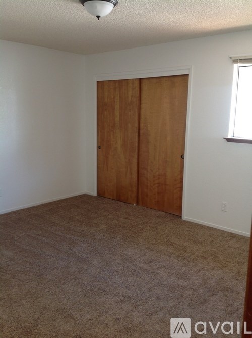 A room with a carpeted floor and a wooden door.