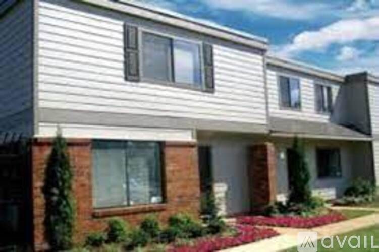 A modern house with a grey siding and a brick pillar.