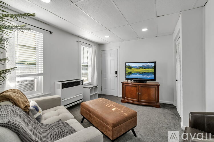 A living room with a television, a couch, and a chair.
