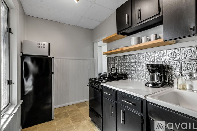 A kitchen with black appliances and a black fridge.