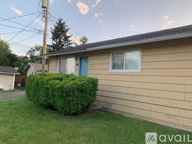 A house with a blue door and a green bush in front.