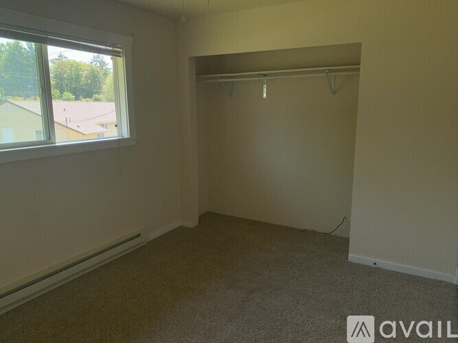 A room with a window and a carpeted floor.