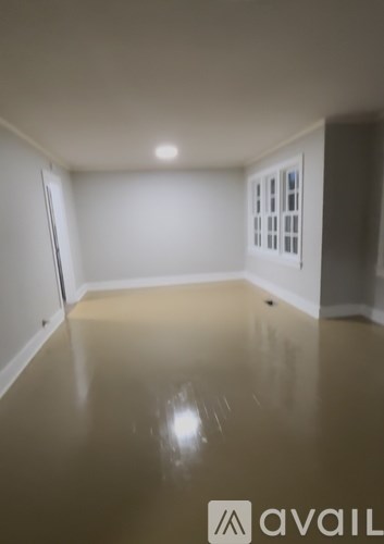 A room with a brown floor and white walls.