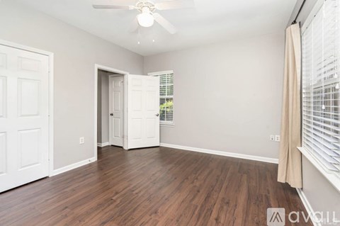 A room with wooden floors and a ceiling fan.