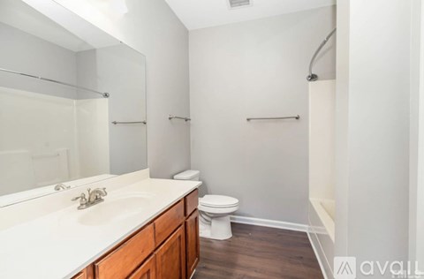 A bathroom with a toilet, sink, and mirror.
