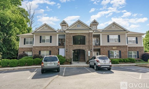 A large brick building with a parking lot in front of it.