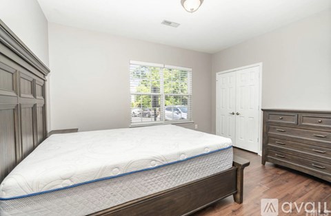 A bedroom with a large bed and wooden furniture.