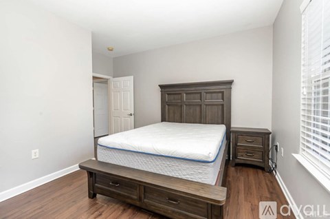 A bedroom with a bed, nightstand, and dresser.