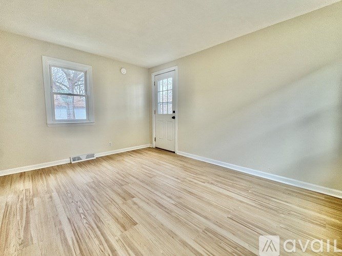 A room with wooden flooring and a door.