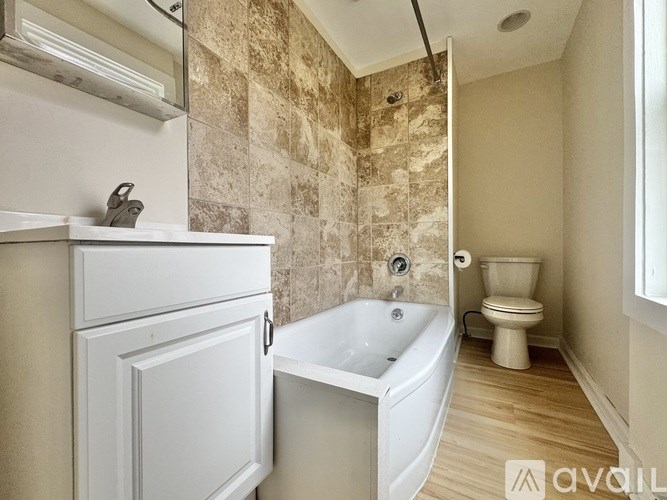 A bathroom with a tub, toilet, and sink.