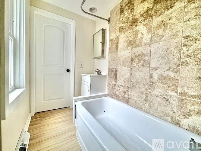 A bathroom with a tub, sink, and toilet.