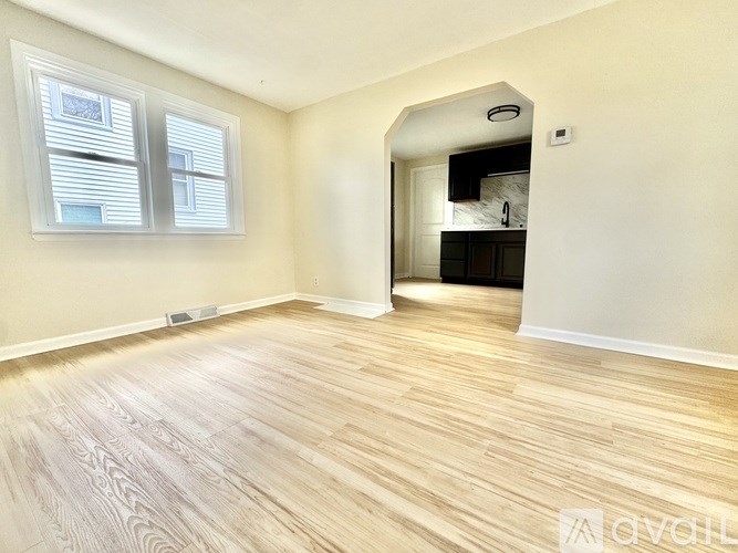 A room with wooden flooring and a window.