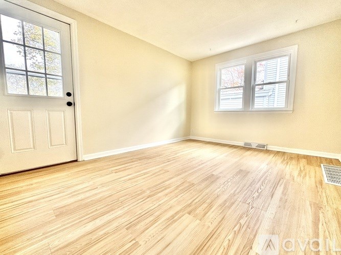 A room with wooden flooring and a white door.