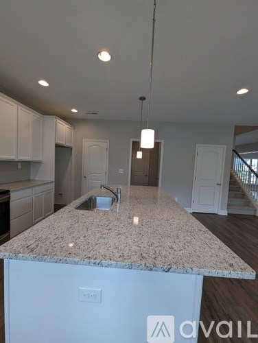 A kitchen with a granite countertop and white cabinets.