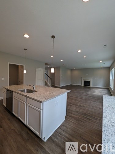 A kitchen with a granite countertop and wooden flooring.