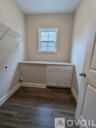A room with a window and a wooden floor.