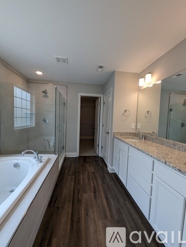 A bathroom with a tub, sink, and mirror.