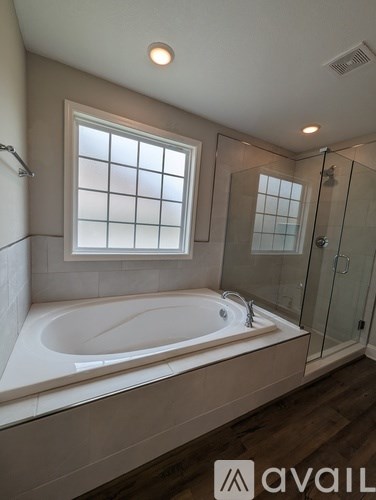 A bathroom with a tub and a window.
