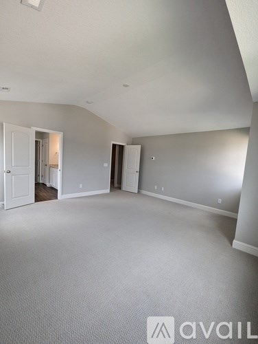 A large empty room with a carpeted floor and white walls.
