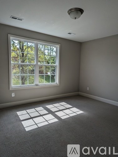 A room with a large window and a carpeted floor.