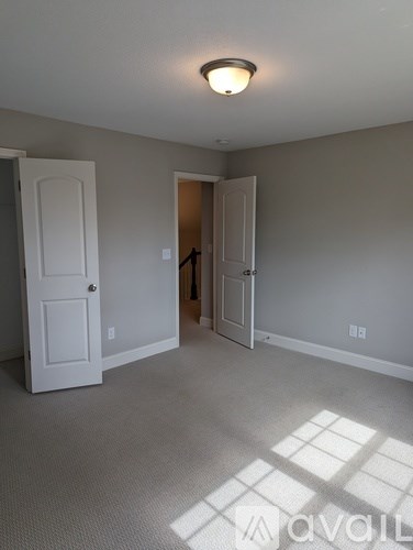 A room with a white door and a carpeted floor.