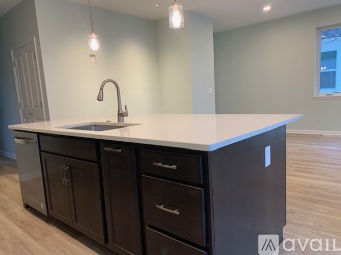 A kitchen with a white countertop and black cabinets.