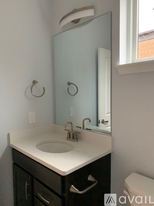 A bathroom with a sink, mirror, and toilet.
