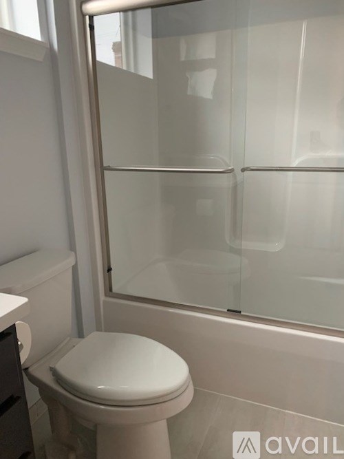 A white toilet in a bathroom with a glass shower door.