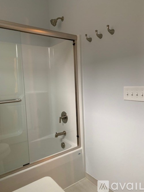 A bathroom with a glass shower door and a toilet.