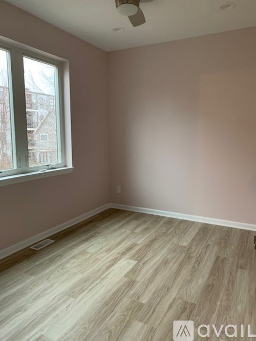 A room with a window and wooden flooring.