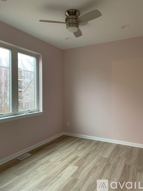 A room with a ceiling fan and a window.