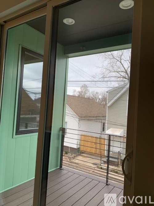 A balcony with a glass door leading to a deck.