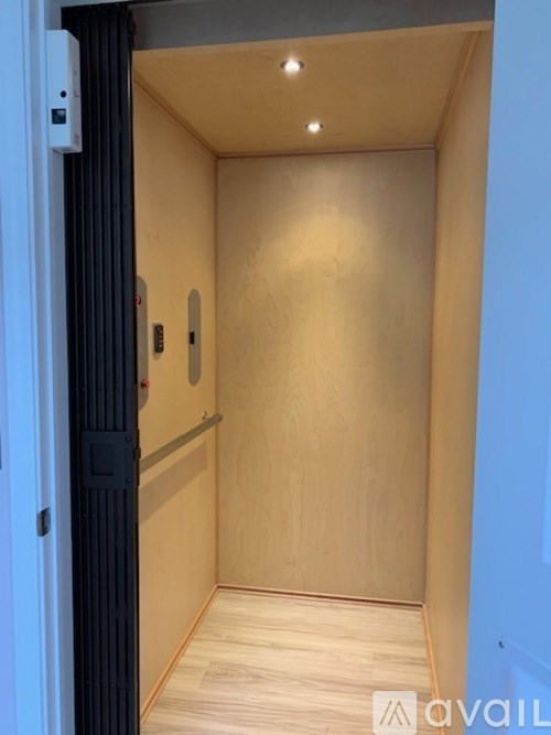 A wooden hallway with a door on the left.