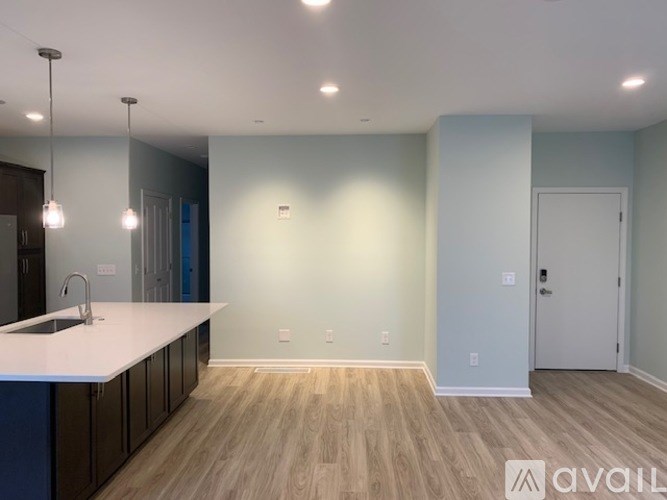 A kitchen with a white countertop and wooden flooring.