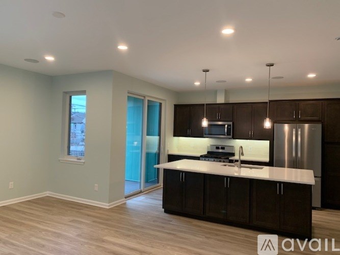A modern kitchen with dark wood cabinets and a white countertop.