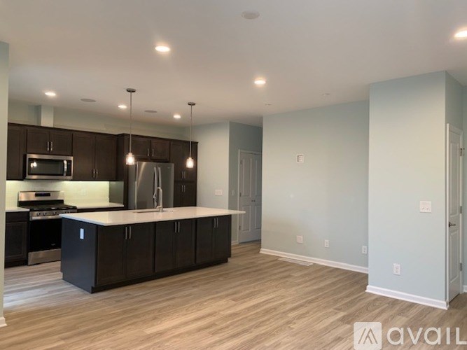 A spacious kitchen with dark brown cabinets and a light countertop.