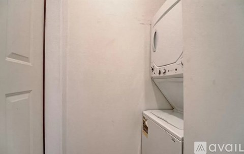 A white dryer is in a small, white room.