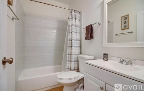 A white bathroom with a toilet, sink, and bathtub.