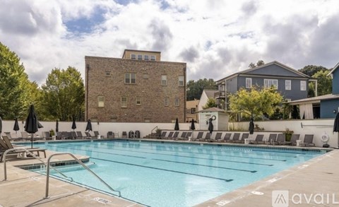 A large outdoor swimming pool with lounge chairs and umbrellas.