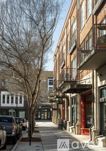 A tree is in front of a building with a balcony.