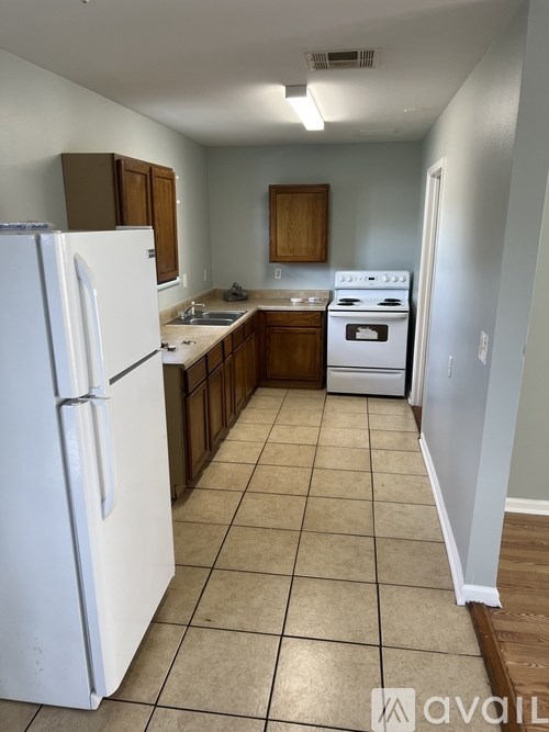 A kitchen with white appliances and brown cabinets.