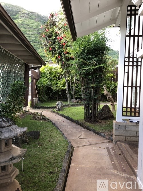 A garden pathway leads to a white gate.