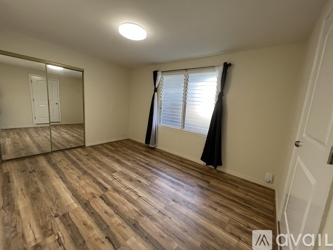 A room with wooden flooring and a sliding door.