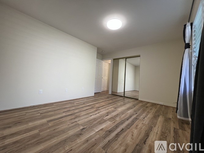 A room with wooden flooring and a sliding door.