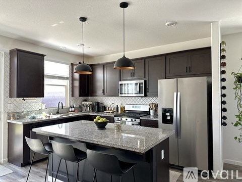 A modern kitchen with a granite countertop and stainless steel appliances.