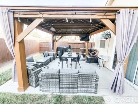 A patio with a table and chairs under a roof.