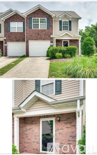 A two-story house with a garage on the first floor and a front porch on the second floor.