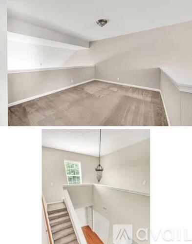 A room with a staircase and a hanging light fixture.